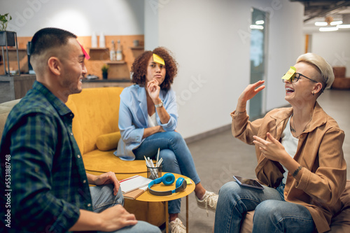 Cheerful company of office workers playing a guessing game