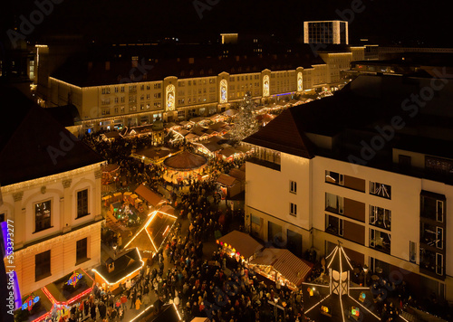 Christmas market in Magdeburg, Saxony-Anhalt with lots of light and people and different stalls. 