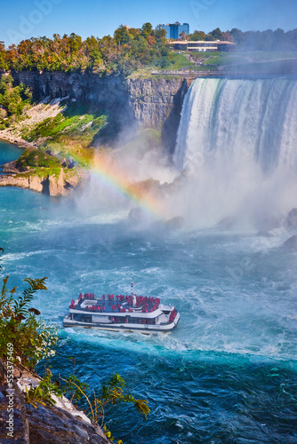 Misty Niagara Falls with rainbow and tourist ship near Horseshoe Falls
