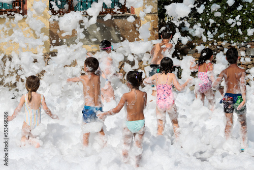 Niños jugando con espuma durante una fiesta