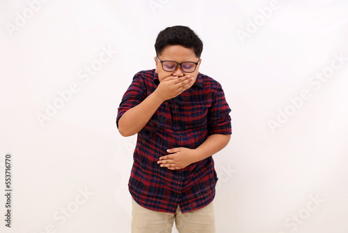 Asian boy standing holding her stomach and feeling nauseous and going to vomit. Isolated on white