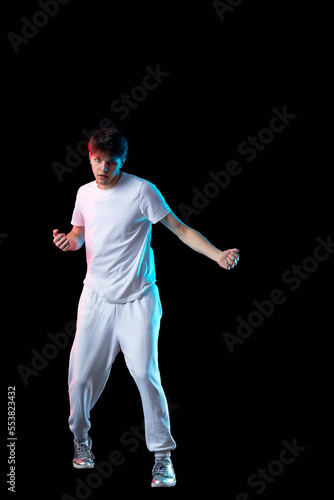 young man in black t-shirt and jeans dancing