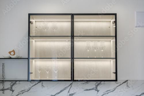 cupboard with lighting with wine glasses in luxure kitchen in studio apartments