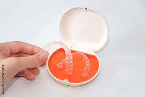 Transparent aligners retainers in a storage case. Invisible braces. Clear teeth straighteners. Orthodontic plastic bracers system