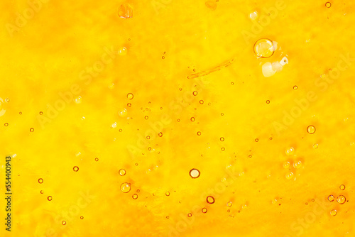 strong extract of gold cannabis wax with high thc close up, bubble shatter texture