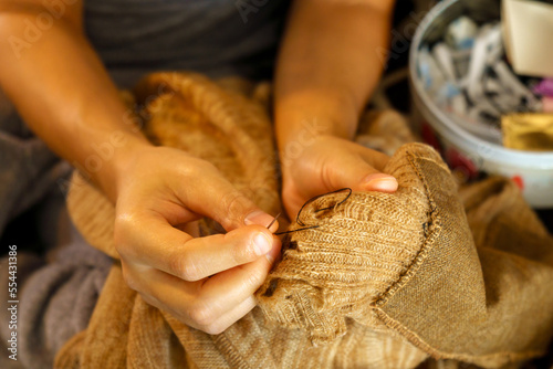 Sew clothes with a needle, mens hands. Sewing and fashionable needlework. Selective focus