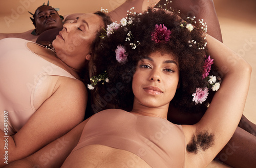 Armpit hair, confidence and floral black woman with natural beauty, body health and happy in skin with a group of women in studio. Creative, flower crown and portrait of a model with hairy underarm