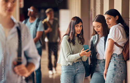 College friends, phone and gossip or fake news about students on social media, internet and mobile app with teenager group talking. Smartphone bullying post of male and female people at university