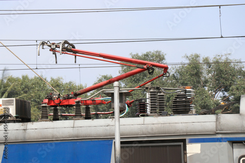 Electric railway trains with the pantograph system connecting with overhead electric lines and a view of rooftop electrical systems