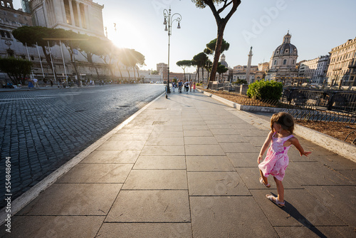 Baby girl against Santa Maria di Loreto church in Rome, Italy.