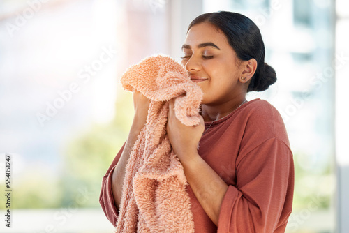 Woman smelling clean laundry, blanket or fabric for fresh and clean smell in house after doing washing, cleaning and housekeeping. Happy female cleaner with textile for aroma, fragrance and scent