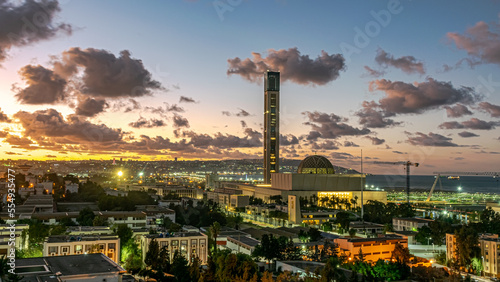 The great mosque of Algiers Djamaa El Djazair and the Martyr's Memorial monument by twilight. Aerial view from Les Dunes Lavigerie, Mohammadia. Mediterranean sea with ships and buildings enlightened.