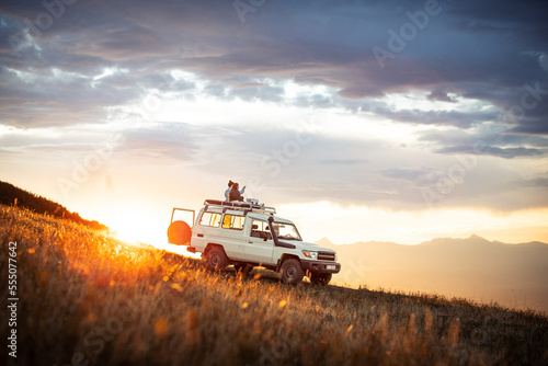 People watching sunset on top of 4x4 vehicle in Mountains of Goden, Kosovo