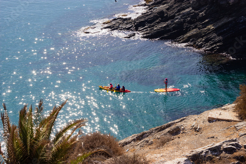 Familia de 4 haciendo kayak en el mar entre rocas