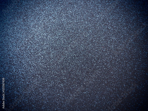 Deep blue shiny bokeh abstract background. Blue - black paper with sparkles. Festive backdrop with dark vignette
