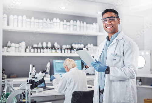 Science, tablet and portrait of a male scientist doing research with technology in a medical laboratory. Happy, smile and man chemist or biologist working on a mobile device in a pharmaceutical lab.