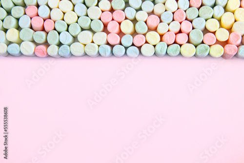 Kolorowe pianki marshmallow na różowym tle 