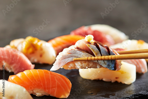 Horse mackerel sushi on chopsticks