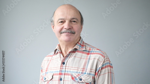 Portrait of smiling mature man standing on white background.