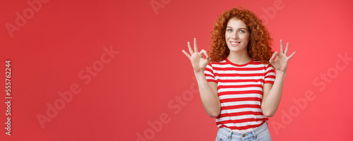 Fine relax everything perfect. Satisfied good-looking redhead cheerful sassy girlfriend curly haristyle show okay ok confirm gesture smiling approval agree good terms stand red background