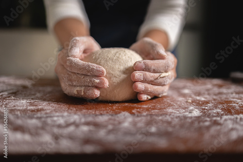 Close up Hand of baker chef is making with flour loaf of dough