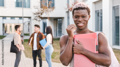 Transgender person smiling at the camera standing in a university campus