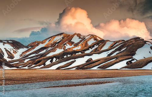 Landscape of volcanic mountain with snow covered and sunset sky among Icelandic Highlands on summer in Landmannalaugar at Iceland