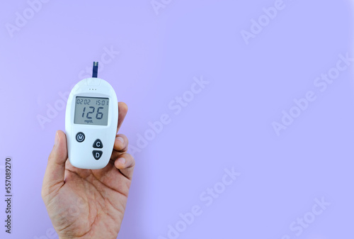 Female hand. Checking for diabetes and checking for hyperglycemia with a digital blood glucose meter. Blood test results 126 are diabetes according to international standards. Health care and medical 