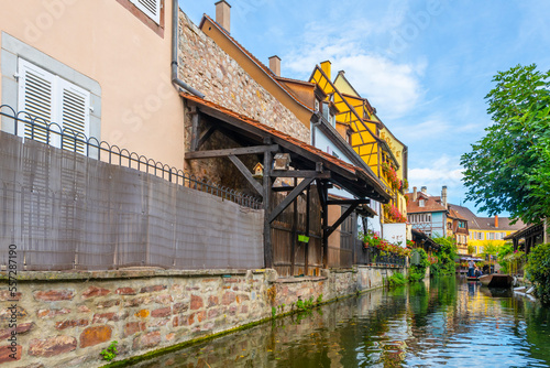 View of half timber homes and cafes from a boat on the Lauch canal in the historic medieval Petite Venice district of Colmar, France, in the Alsace region. 