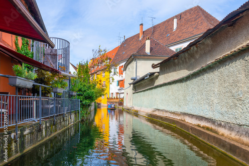 View of half timber homes and cafes from a boat on the Lauch canal in the historic medieval Petite Venice district of Colmar, France, in the Alsace region. 