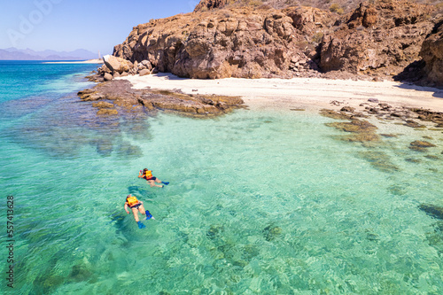 playa con agua cristalina y dos personas nadando