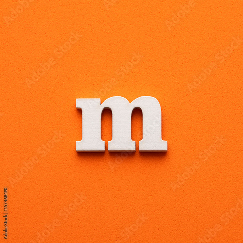 m white lowercase letter - Background in orange foamy