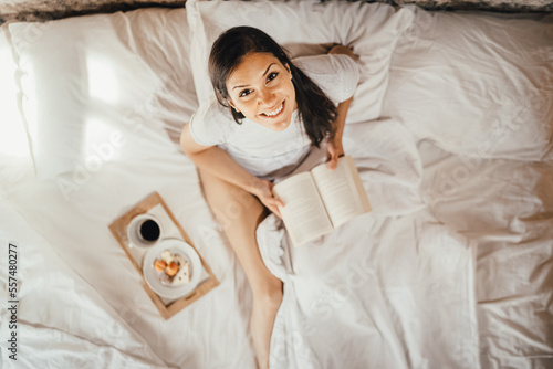 Optimistic young woman enjoying relaxed morning.Morning ritual,gratefulness and mindfulness concept.Leasure wellnes day off.Quality free time.Relaxed day at home.Cosy home comfort.Reading a book