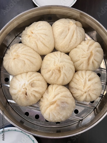 Eight asian pork buns in stainless steel steamer, where they just cooked, now ready to be served
