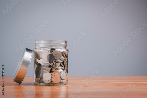 Filter effect retro vintage style for money in the glass jar on wooden table. Save money concept for Finance Banking Business Ideas, Investments, Funds, Bonds, Dividends and Interest.