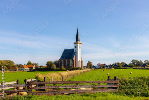 Typical landscape of Texel island, Small village and picturesque church (Hervormde kerk van Den Hoorn) on the green grass meadow polder, A little town on the wadden islands, North Holland, Netherlands