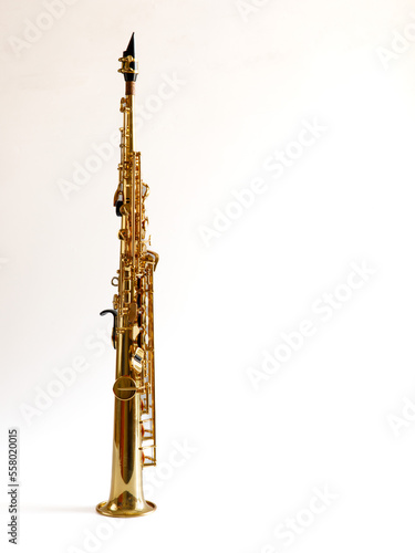 Soprano Sax, wind instrument saxophone staying on a white background, vertical, copy space