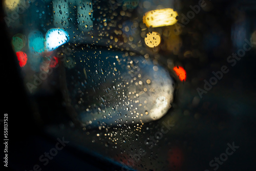 Close-up view of a car's side mirror in the rain at night. High quality photo