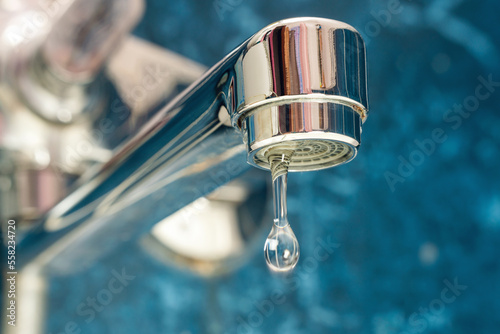 A drop of water drips from a leaky faucet