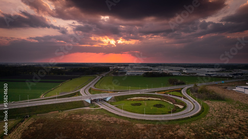 estakada na autostradę a8 z magazynami w tle o zachodzie słońca z drona