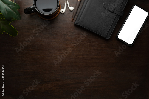 Top view, flat lay smart phone notebook and coffee cup on wooden table. Copy space and blank screen for your advertise design.