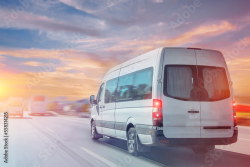 Passenger white minibus accelerating ride motion blur effect, in the morning at dawn.