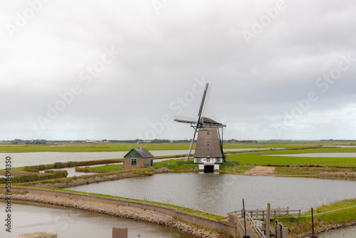 Traditional Molen Het Noorden (Windmills The North) is a polder mill, Dutch landscape with flat and low land with cloudy sky, Oosterend, Texel is the wadden islands in the Netherlands, North Holland.