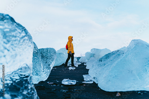 Woman walking along the diamond beach in Iceland.