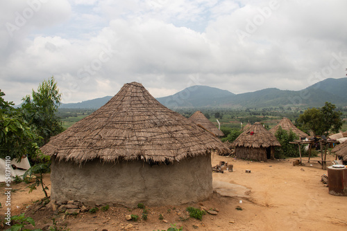 African village in Nigeria near capitol city of Abuja. Traditional African houses made of mud walls and wattle roofs, with untouched nature with hills and mountains in background