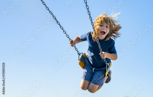 Swinging on playground. Funny kid on swing. Little boy swinging on playground. Happy cute excited child on swing. Cute child swinging on a swing. Crazy playful child swinging very high.