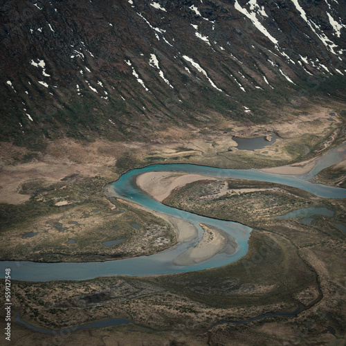 Turquoise river bends through landscape from above the hike to Knutshoe summit in Jotunheimen National Park in Norway