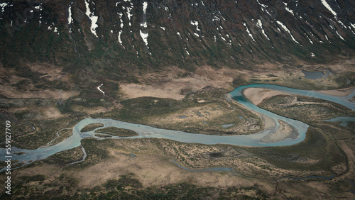 Turquoise river bends through landscape from above the hike to Knutshoe summit in Jotunheimen National Park in Norway