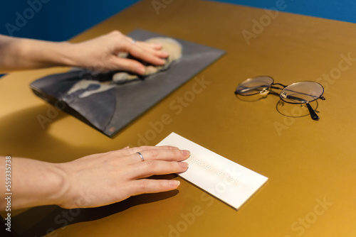 Female hands touches exposition in museum. Convex exhibit for visually impaired and blind people. Braille and accessibility for disabilities people. Top view