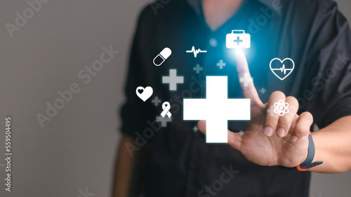 Businessman hold virtual plus medical network connection icons. Covid-19 pandemic develop people awareness and spread attention on their healthcare.Doctor,document,medicine,ambulance,patient